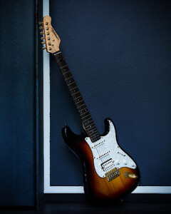 Gitarre in braun-weißer Optik an einer Wand