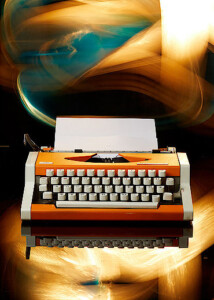 Nostalgische Schreibmaschine in orange mit bunten Effekten und Spiegelung