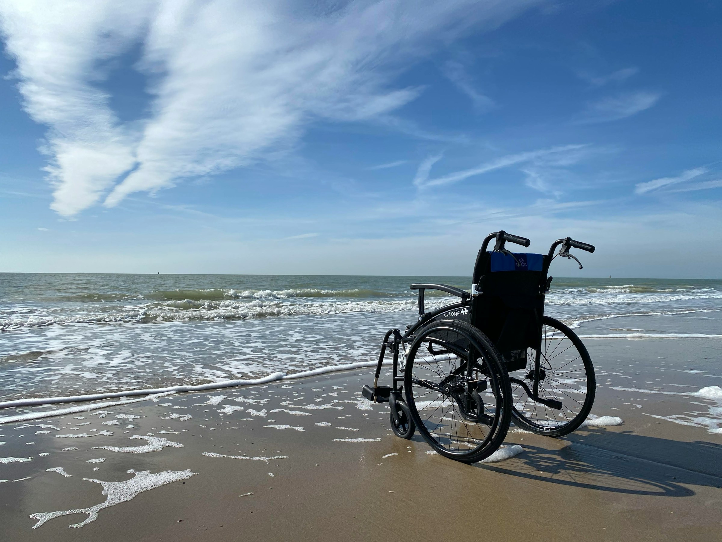 Leerer Rollstuhl am Meer mit blauem Himmel